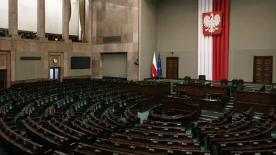 Pusta sala plenarna Sejmu widziana szerokim kadrem w spokojnym świetle